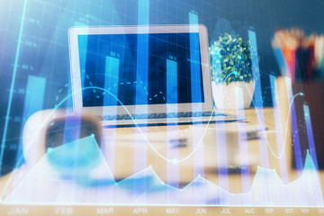 Stock market graph on background with desk and personal computer. Multi exposure. Concept of financial analysis.