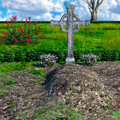 View of a large, well-groomed grave in a cemetery with plants during the day and great cloud cover. Large metal christian cross