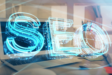 Multi exposure of table with computer and seo drawing hologram. Search optimization concept.