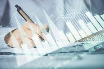 Multi exposure of woman's hands making notes with forex graph hologram. Concept stock market...