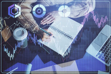 Forex graph on hand taking notes background. Concept of research. Double exposure