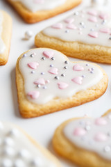 Flat lay of cookies hearts with icing and decorated for Valentine's Day, white background. Valentine's day concept.