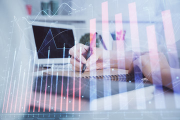 Financial graph displayed on woman's hand taking notes background. Concept of research. Double exposure