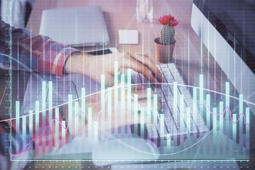 Double exposure of stock market chart with man working on computer on background. Concept of financial analysis.