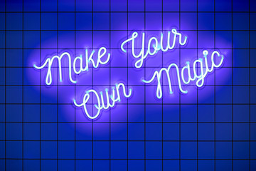 Handwritten neon glowing text Make Your Own Magic on blue tiled wall. Trendy classic color....