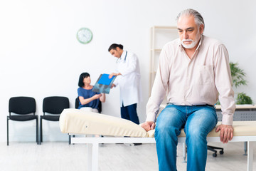 Fototapeta premium Old couple visiting young male doctor