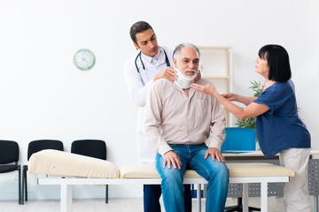 Obraz premium Old couple visiting young male doctor