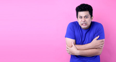 Portrait Handsome Asia man feeling cold on pink background in studio With copy space.