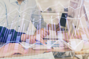 Multi exposure of chart with man typing on computer in office on background. Concept of hard work.