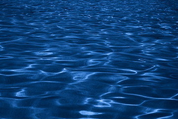 Water texture background representing the color of the year 2020 classic blue. Toned photo.