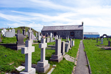 Naklejka premium A path leads through a graveyard to the old chapel of Saint Patrick at Cemaes on the beautiful Welsh island of Anglesey.