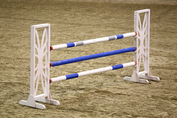 Image of show jumping poles on empty training field.