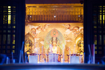 View from the low angle view of incense stick look through the Buddha Tooth Relic statue.
