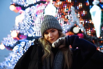 beautiful girl in winter hat near the Christmas tree, winter holidays, holiday and walks photo...