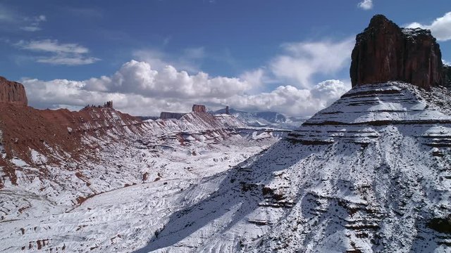 Panning aerial view of Parriott Mesa covered in snow during winter in Castle Valley Utah.