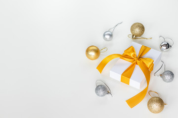 Paper gift box wrapped with yellow ribbon with Christmas decorations, isolated on white background. Presents and holidays concept.