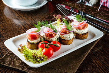 Salted lard and salted bacon with black bread, garlic, onion and horseradish sauce on a wooden board