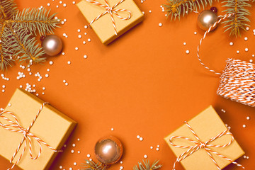 Christmas composition with gifts, branches and holiday elements on the orange background. Flat lay. Merry Christmas, New Year, winter concept.