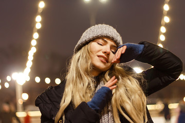 beautiful girl in winter hat near the Christmas tree, winter holidays, holiday and walks photo...