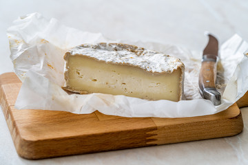 Half Cut Whole Brie Cheese with Knife on Wooden Board also called Turkish Mera from Goat Milk.