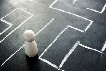 Manage your career concept. Wooden figurine in the labyrinth.