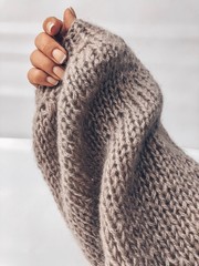 female hand in a beautiful knitted sleeve