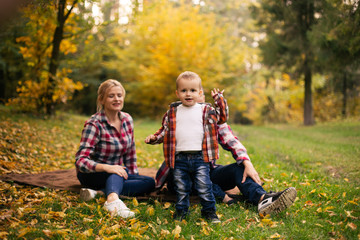 Fototapeta premium Little cute son playing with parents in forest