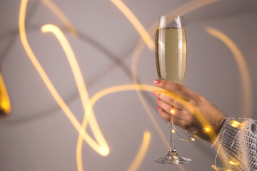 Minimalistic christmas concept of champagne in a female hand.