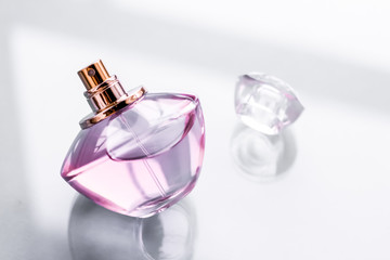 Pink perfume bottle on glossy background, sweet floral scent, glamour fragrance and eau de parfum...