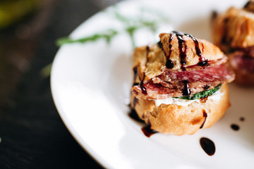 Cheese donuts with salami and cucumbers under balsamic sauce. Catering