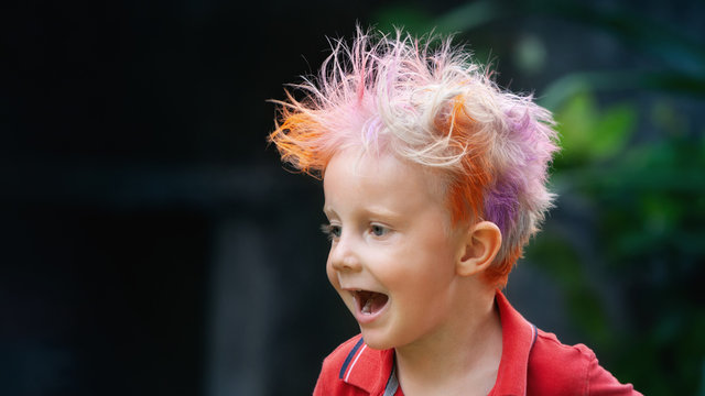 Funny portrait of boy with messy hairstyle. Crazy hipster kid. Stylish boy with painted colorful hair. Happy children having fun and celebrating at party in family summer camp. positive and cheerful.