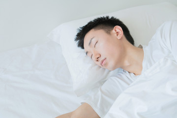 side view of bearded man sleeping on bed, lying on side