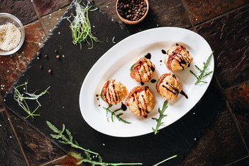 Cheese donuts with salami and cucumbers under balsamic sauce. Catering