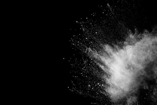 Freeze motion of white color powder exploding on dark background. 