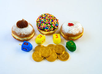 Fresh donuts, gold coins and wood dreudel s for Hanukkah celebration.