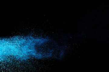 Fototapeta na wymiar Abstract brown powder explosion. Closeup of blue dust particle splash isolated on black background.