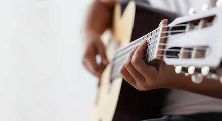 Woman hands playing acoustic classic guitar the musician of jazz and easy listening style select focus shallow depth of field with copy space - obrazy, fototapety, plakaty