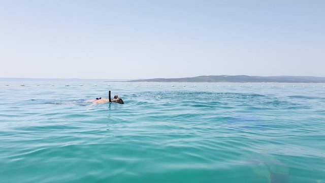 Happy couple snorkeling with masks and flippers near sea buoys