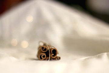 Cinnamon sticks on white background with bokeg lights. Selective focus.