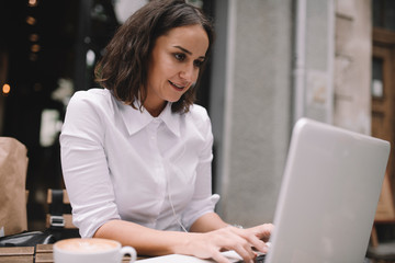 Young businesswoman working in cafe. Beautiful woman having a video call in coffee shop. 