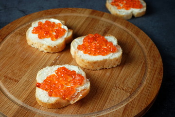 Sandwiches with red caviar on a dark background. Seafood, healthy food