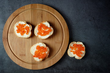 Sandwiches with red caviar on a dark background. Seafood, healthy food