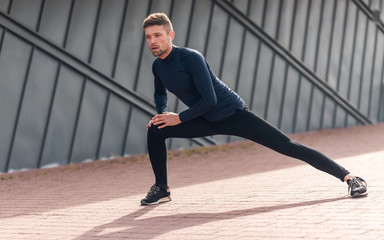 Fototapeta premium Male athlete doing warm up exercises. Sport, workout, healthy lifestyle concept.