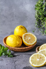 Photo of fresh ripe lemons on dark background. A slice of lemon with green leaves. Lemon fruit on...