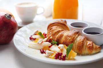 Buttery croissant, chocolate, jam and fresh fruit salad.