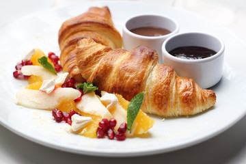 Buttery croissant, chocolate, jam and fresh fruit salad.