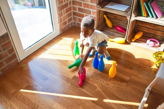 Beautiful african american toddler playing bowling at kindergarten