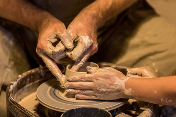 Naklejka premium hands of potters on potters wheel