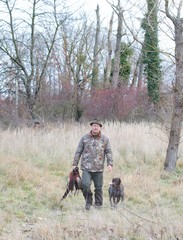 Hunter and German pointer carries pheasants