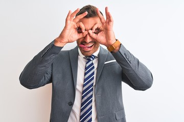 Young handsome business man wearing suit and tie over isolated background doing ok gesture like binoculars sticking tongue out, eyes looking through fingers. Crazy expression.